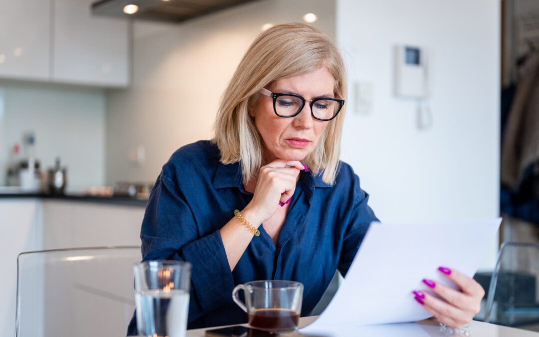 Woman sitting at counter and looking at paperwork for inherited IRA