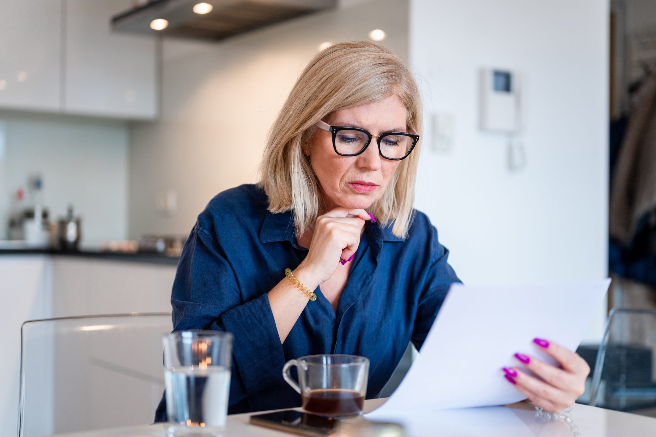 Woman sitting at counter and looking at paperwork for inherited IRA