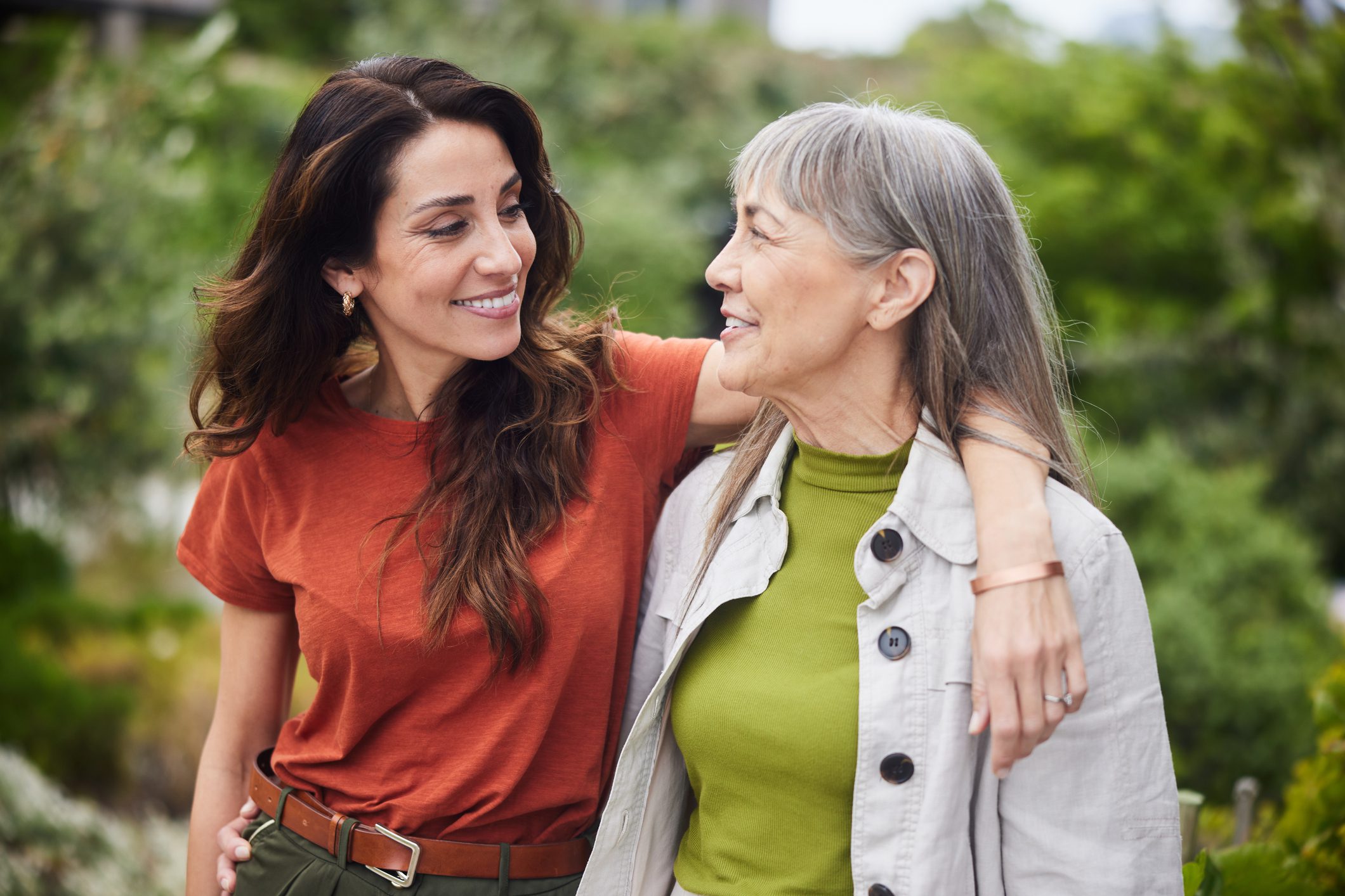 Mom and daughter walking with daughters arm around her mm discussing the future and finances