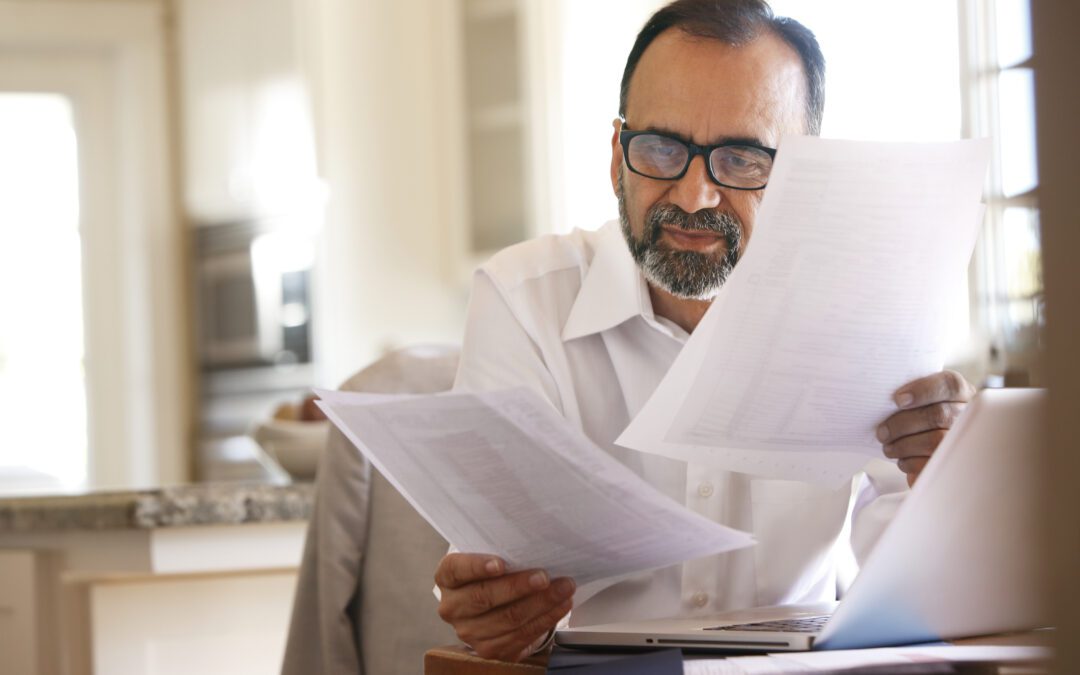 Man looking at paperwork as he plans for 2024 taxes