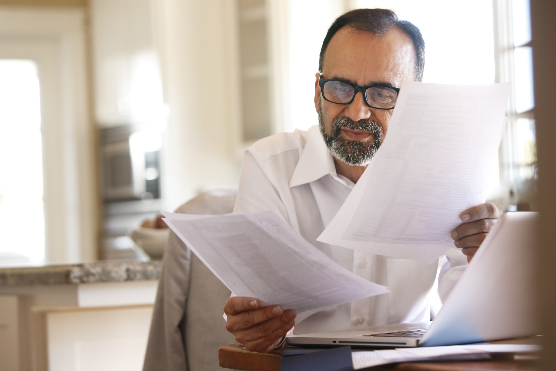 Man looking at paperwork as he plans for 2024 taxes